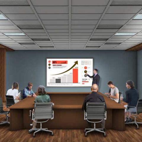 Digital representation of a conference room with people sitting around a table and someone presenting at a screen